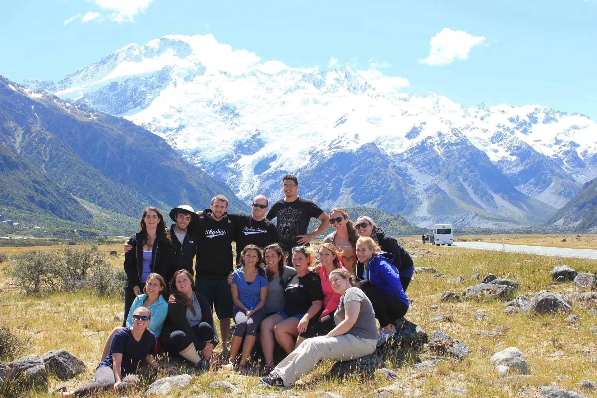 group travel in front of snowy mountains