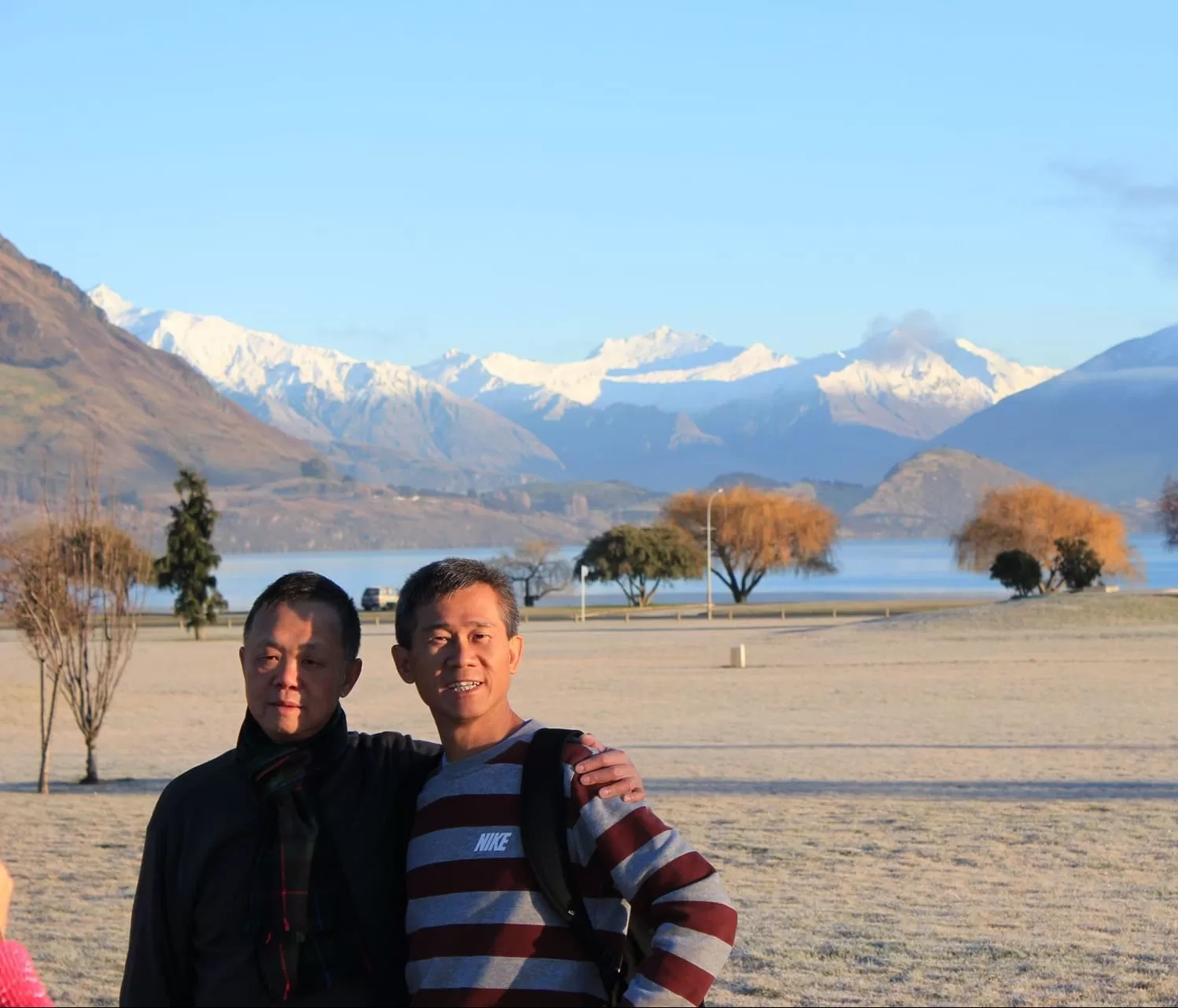 two men standing in front of snow capped mountains background